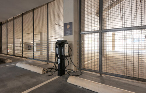 Alt text/image text: Say Goodbye to Daily Hassles - covered parking with electric car charging stations